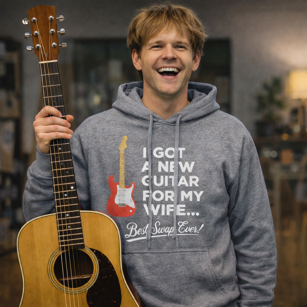Laughing man holding a guitar, wearing a heather hoodie saying "I Got A New Guitar For My Wife.